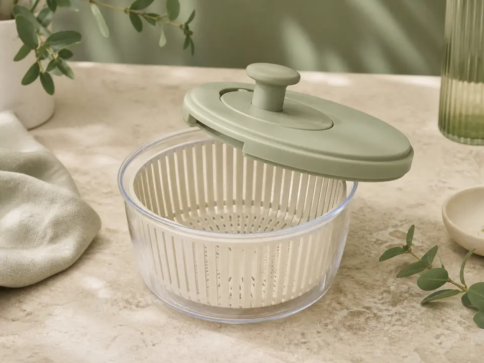 Compact clear salad spinner with a soft sage lid