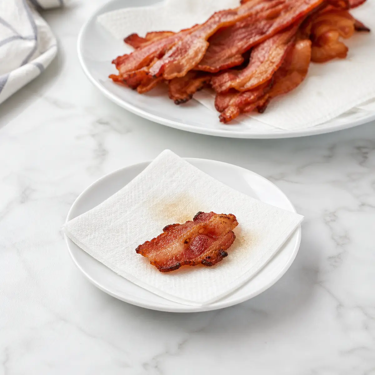 A tiny bacon piece set apart from a larger bacon serving