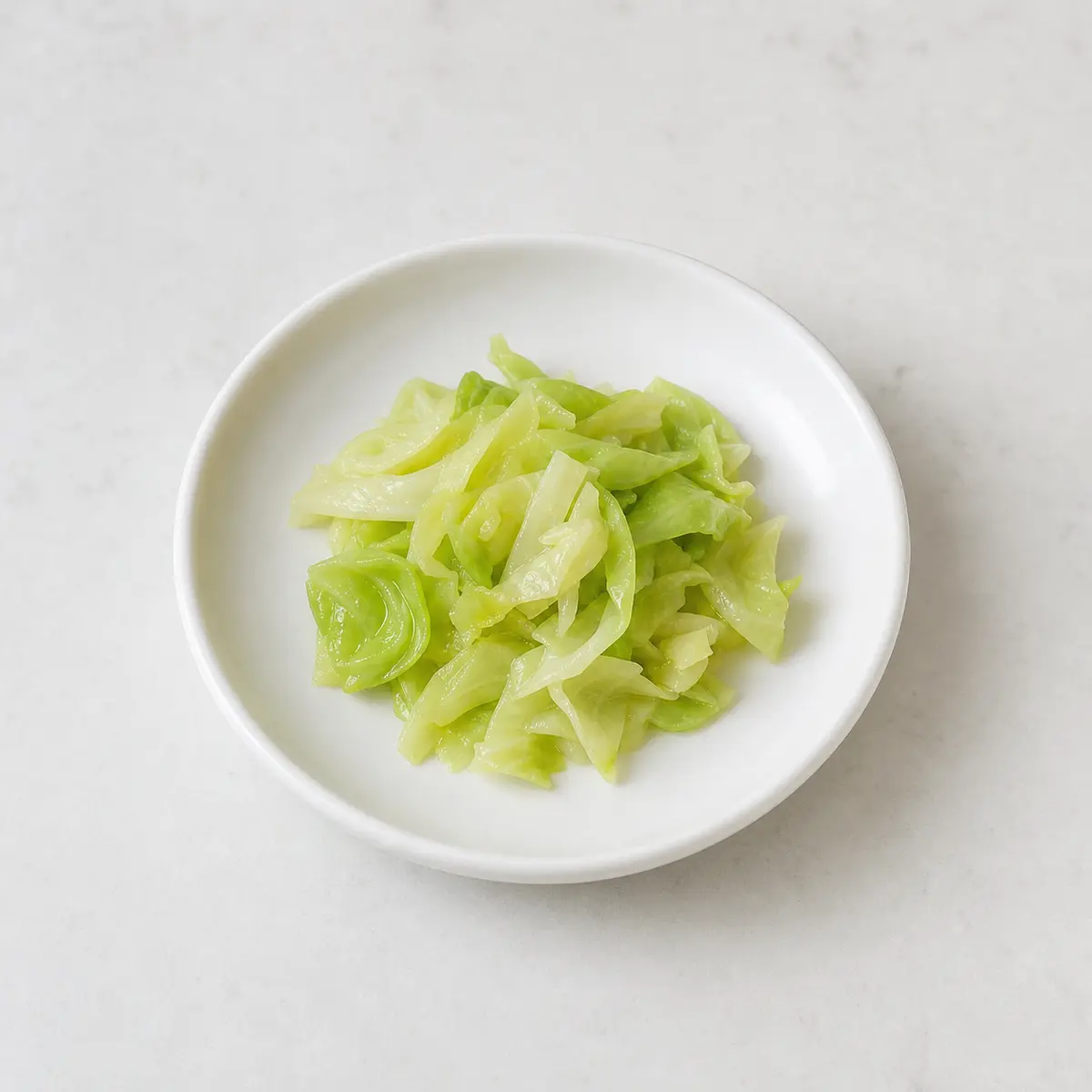 Tiny plain cabbage shreds on a saucer