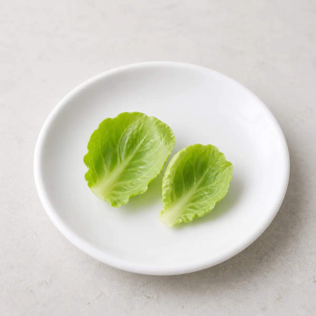 Tiny washed cauliflower leaves on a saucer