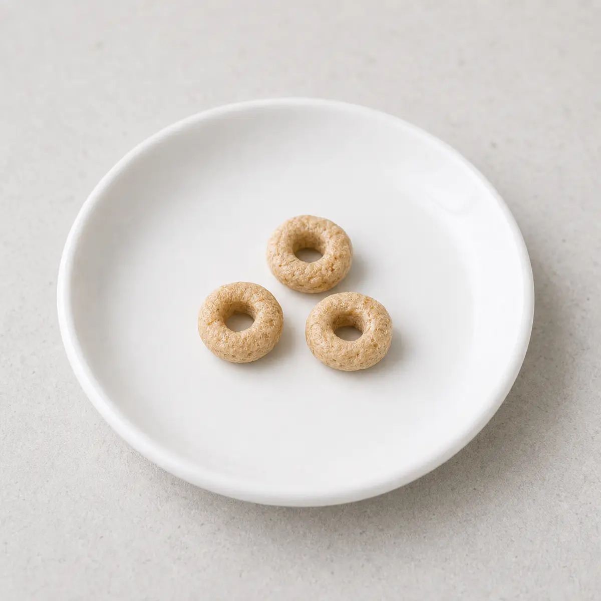 Three plain oat cereal rings on a saucer