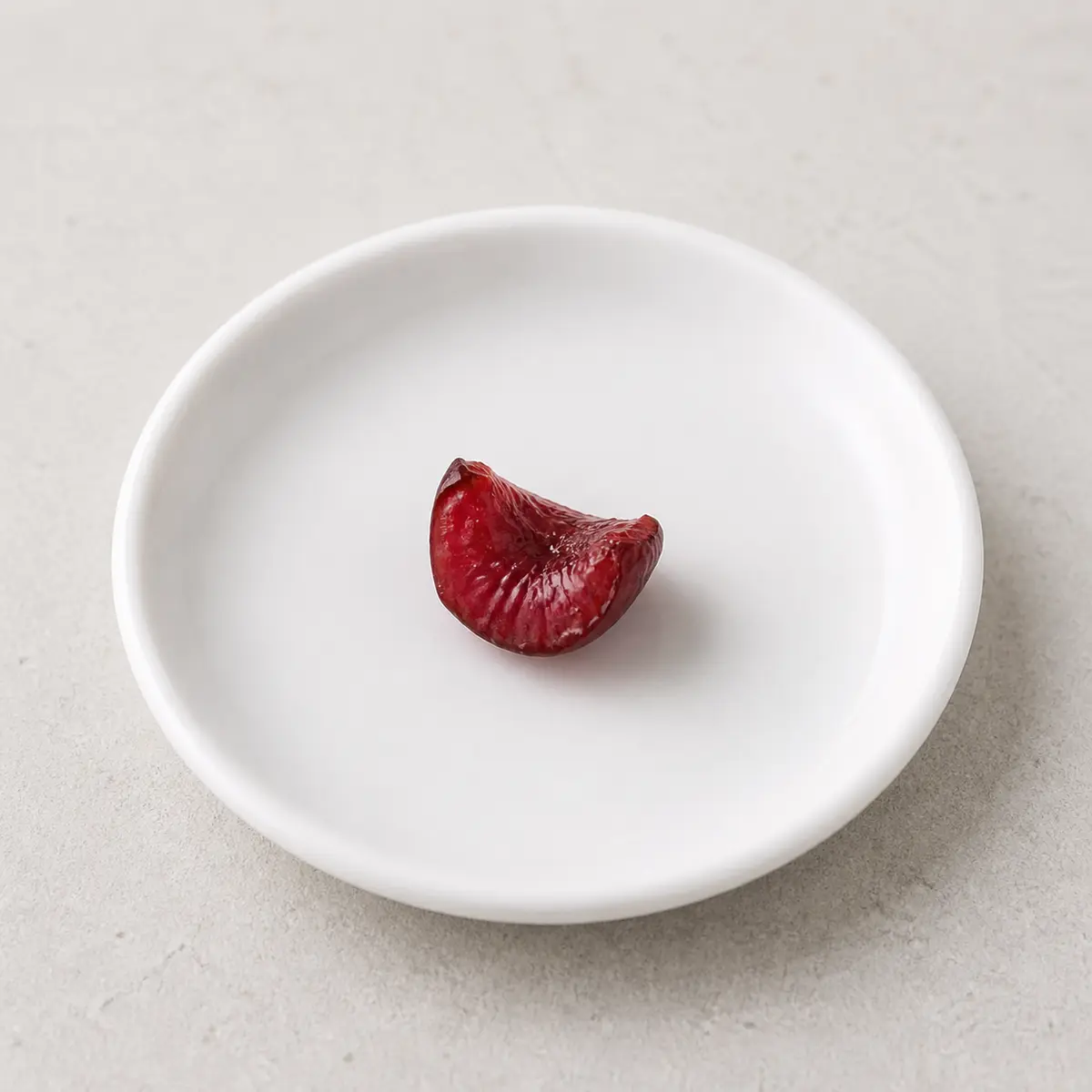 Tiny pitted cherry flesh piece on a saucer