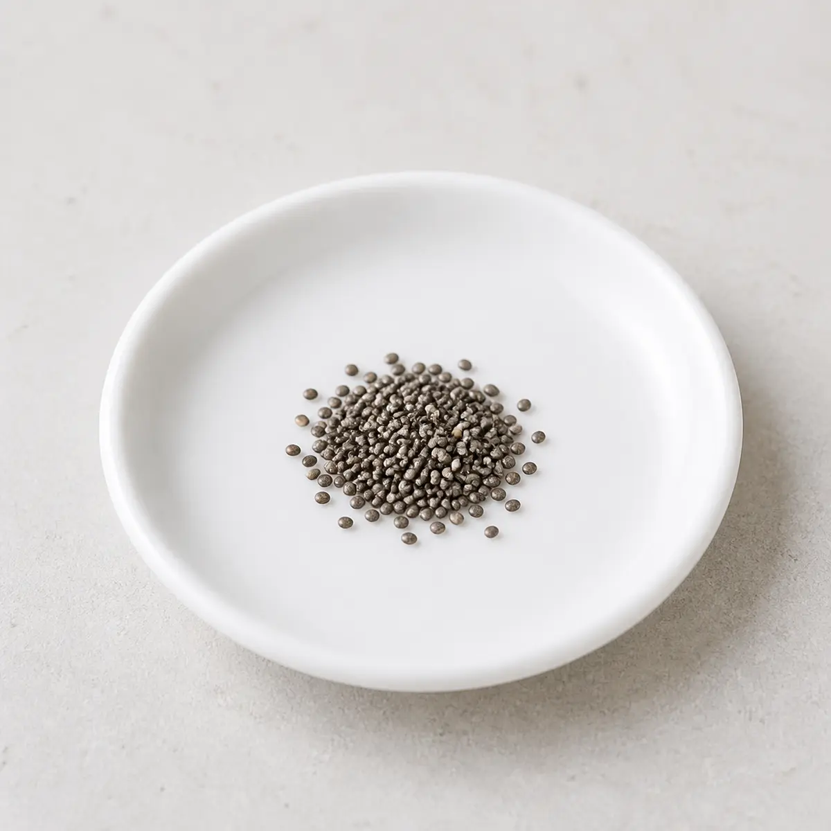 Tiny pinch of plain chia seeds on a saucer