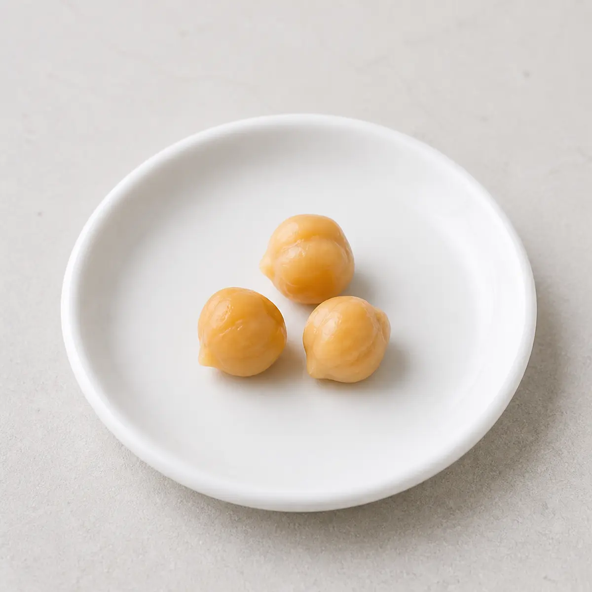 Tiny plain cooked chickpeas on a saucer