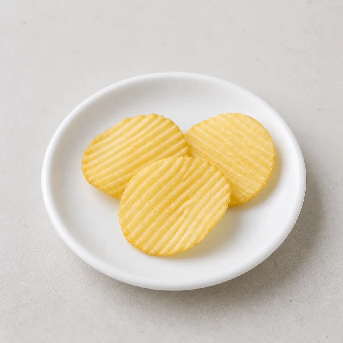 Plain ridged potato chips on a saucer