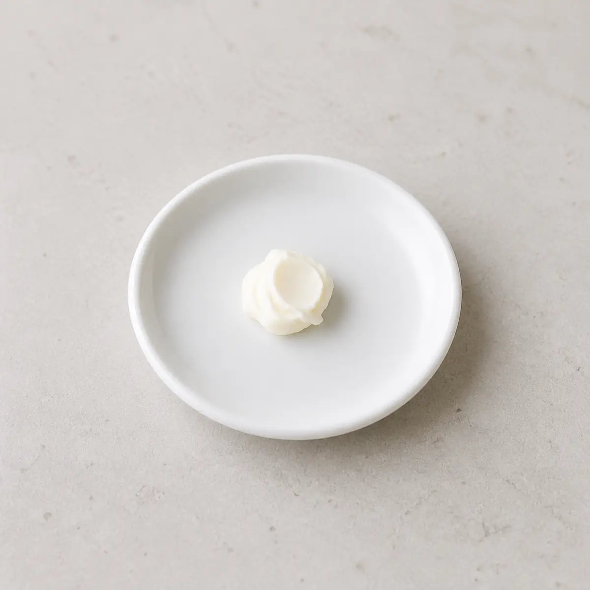 Tiny plain cream cheese dab on a saucer