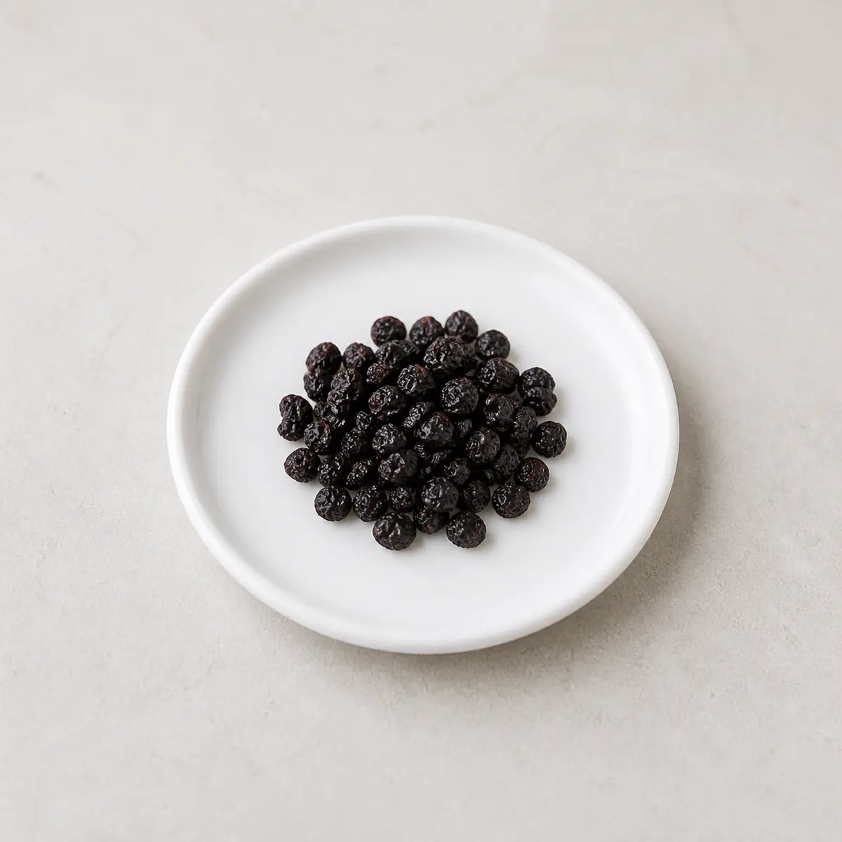 Dried black currants on a white plate