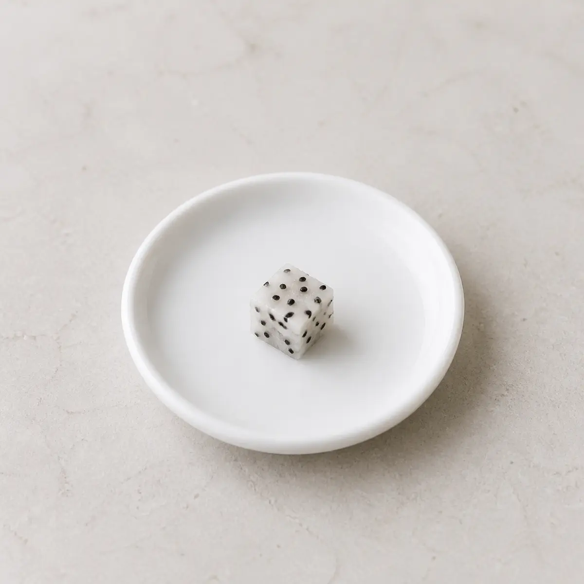 Tiny dragon fruit cube on a saucer