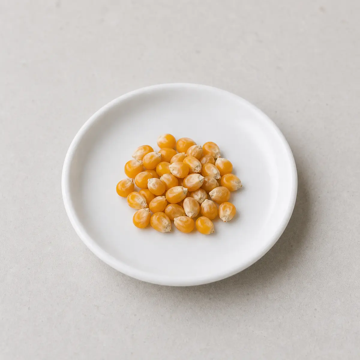 Hard dried corn kernels on a white plate