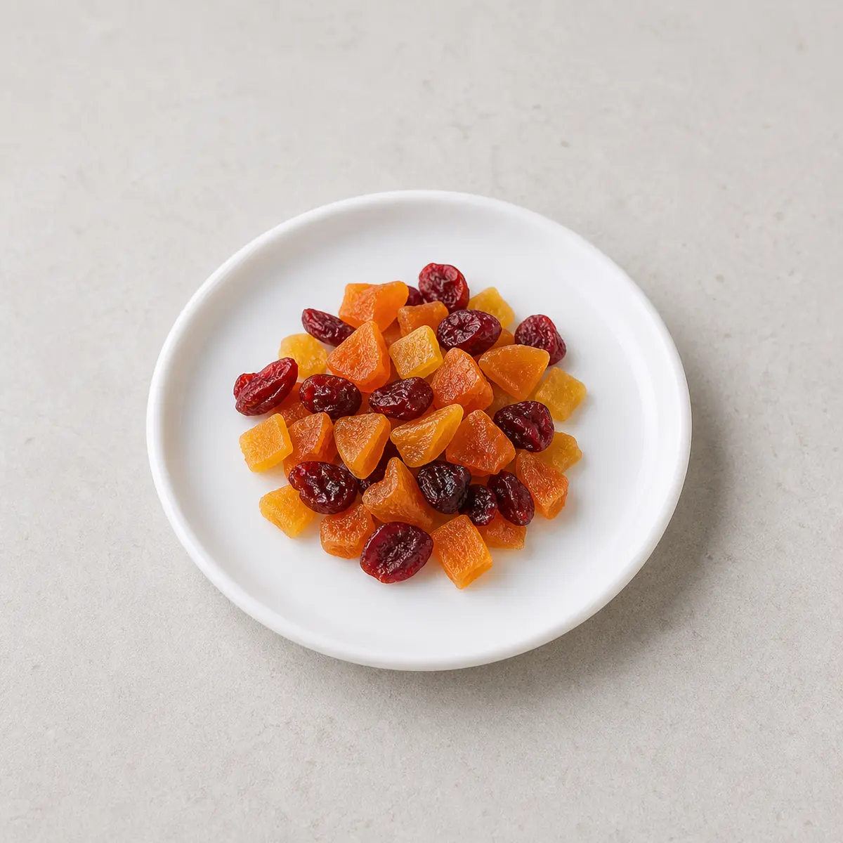 Mixed dried fruit pieces on a white plate
