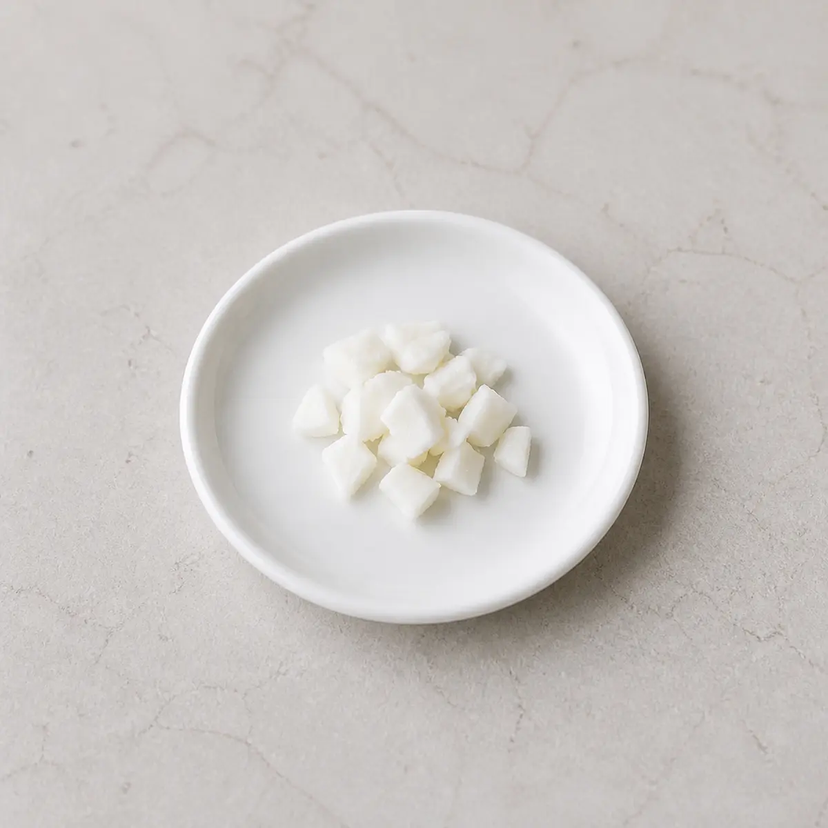 Tiny fully cooked egg white pieces on a saucer