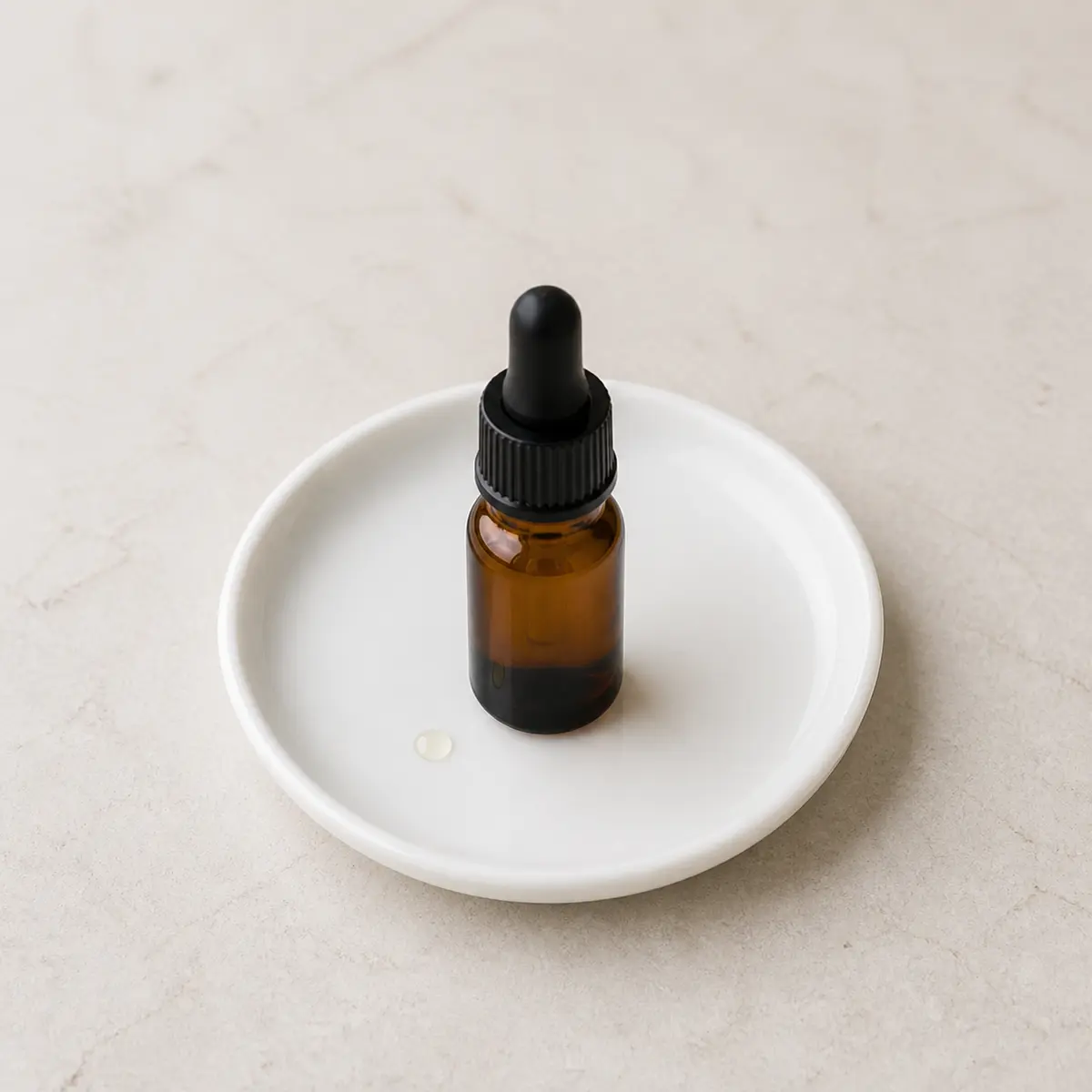 Unlabeled amber essential oil bottle on a white plate