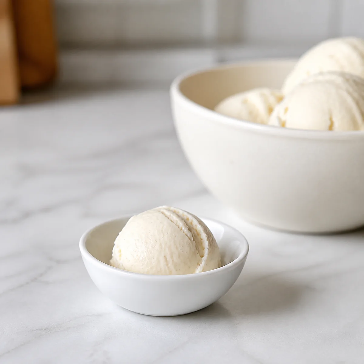 Small scoop of plain vanilla ice cream in a white dish