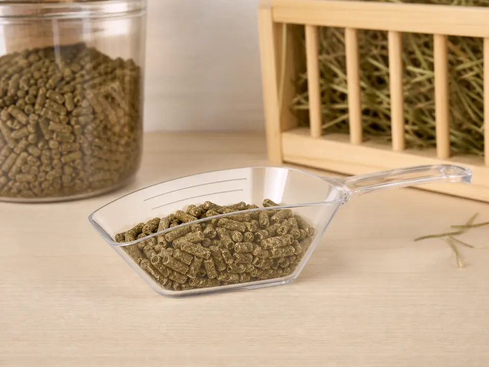 Clear marked scoop holding plain rabbit pellets beside an airtight container